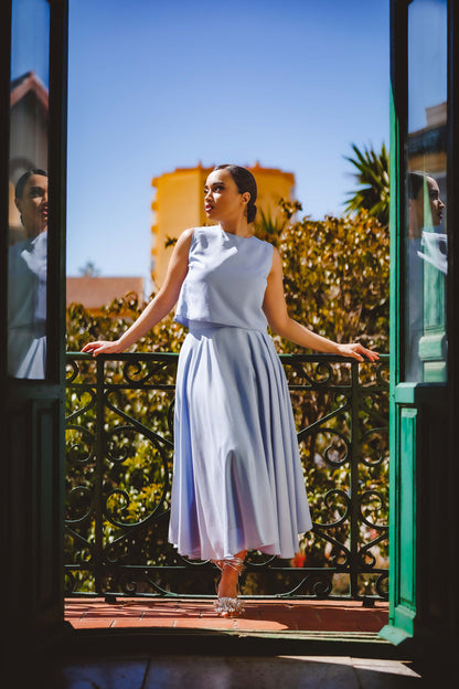 Mujer con un conjunto de top y falda de color azul bebé y confeccionado de tejido tencel marca podenco