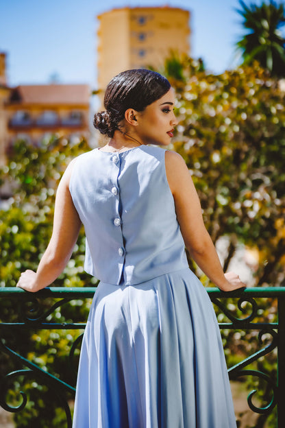 Mujer de espaldas con un conjunto de top y falda de color azul bebé y confeccionado de tejido tencel marca podenco